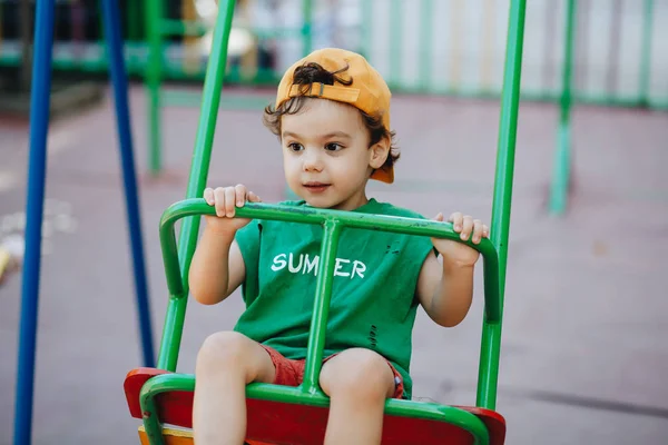 Beau petit garçon filant sur une balançoire d'été avec espace pour le texte — Photo