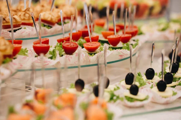 Όμορφα διακοσμημένο τραπέζι γευμάτων με διάφορα σνακ τροφίμων και ορεκτικά με σάντουιτς, χαβιάρι, φρέσκα φρούτα για την εταιρική χριστουγεννιάτικη εκδήλωση γενεθλίων ή γαμήλια γιορτή — Φωτογραφία Αρχείου