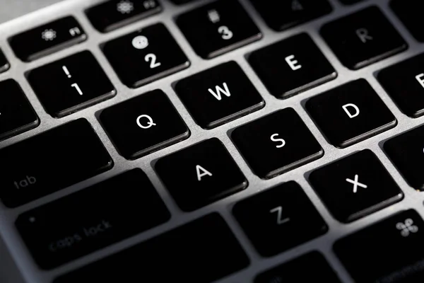 Extreme close-up van een modern zilveren toetsenbord met zwarte knop. — Stockfoto
