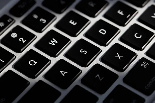 Primer plano extremo de un teclado moderno de plata con botón negro . — Foto de Stock