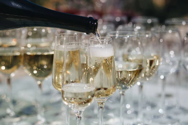 El camarero vierte champán en copas en la calle - catering de bodas - mira desde abajo — Foto de Stock