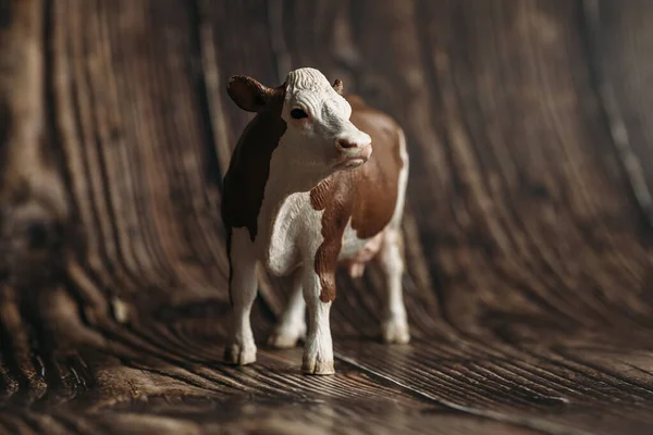 figure of a toy cow on a wooden background