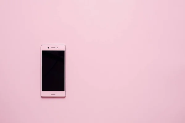 pink Smartphone or Mobile phone on pink background with copy space. Flat lay. Top view. High quality photo