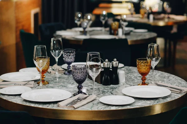 Stolní nádobí brýle, květinová vidlička, nůž sloužící k večeři v restauraci s útulným interiérem Royalty Free Stock Fotografie