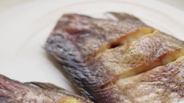 Beyaz arka planda bir tabakta kızarmış gourami, Tayland yemeği. Yan görünüm