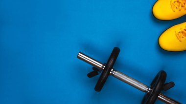 Üstten görünüm spor snickers ve halter parlak mavi arka plan ayarla