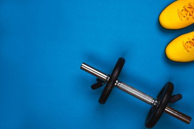 Spor yatay kompozisyon snickers ve parlak mavi arka plan üzerinde halter üstten görünüm