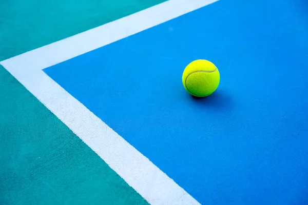 Tennisboll på hårda moderna blå domstolen nära vit linje — Stockfoto
