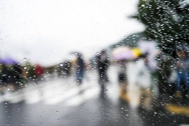 Mavi cam arka plan üzerinde yağmur damlaları. Sokak Bokeh ışıklar odak. Renkli şemsiyeler. Sonbahar zemin