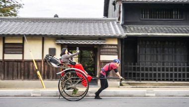 Fotoğraf selfie geleneksel Japon arabası çekti el çekçek: Nara, Japan sürme telefon alarak Nara Japonya 09.18.18 mutlu neşeli kadın.