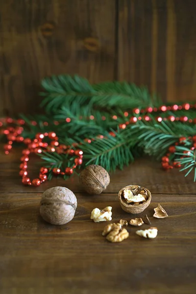 Rustykalne tło z orzechami, jodła drzewo gałąź i czerwone kulki kulki świątecznych dekoracji. można go używać z życzeniami lub kuponu. Kopiować miejsca na tekst. Koncepcja natura nowy rok. — Zdjęcie stockowe
