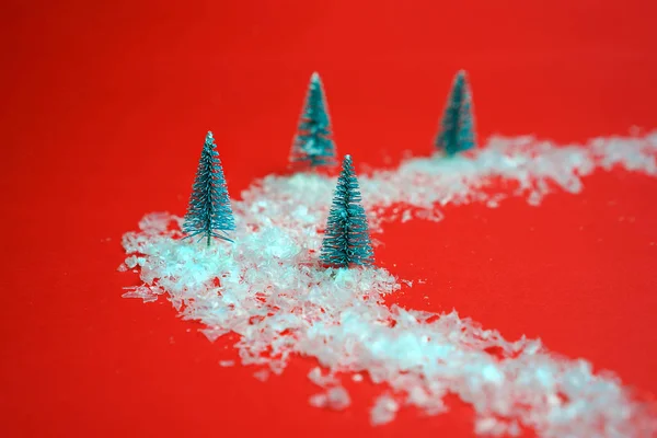 Flat lay snowy christmas trees with snow on road on red background. Minimal New Year concept. Top view