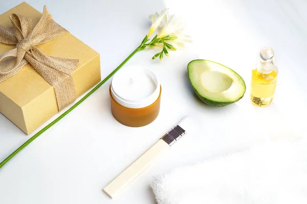 Beauty concept avocado skin care facial essence oil, soap, lily flower and towel on white background. Facial treatment preparation for cosmetic clinic. copy space. SPA and sauna beauty concept. — Stock Photo, Image