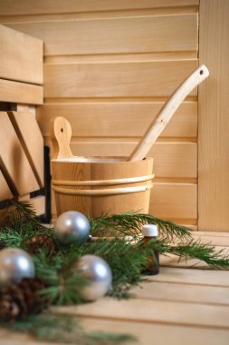 Spa, sauna ve sağlık ayarı su kovası ile yağ özü, koniler, Noel ağaç dalları, ahşap arka plan üzerinde beyaz havlu. Sonbahar Kış sağlık kavramı relax ve tedavi tedavi. Yakın çekim