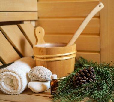 Spa, Fin saunası ve sağlık ayarı su kovası ile yağ özü, koniler, Noel ağaç dalları, ahşap arka plan üzerinde beyaz havlu. Sonbahar Kış sağlık kavramı relax ve tedavi tedavi.