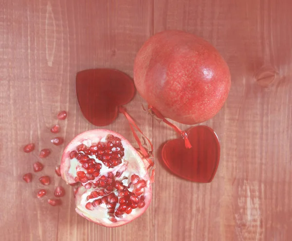 Panton Farbe des Jahres 2019 - lebende Korallen. abstrakte natürliche Hintergrund frisch geschälte Granatäpfel mit rubinroten Bohnen in Liebe mit zwei Herzen auf alten Holztisch. Valentinstag-Konzept abgeschwächt — Stockfoto