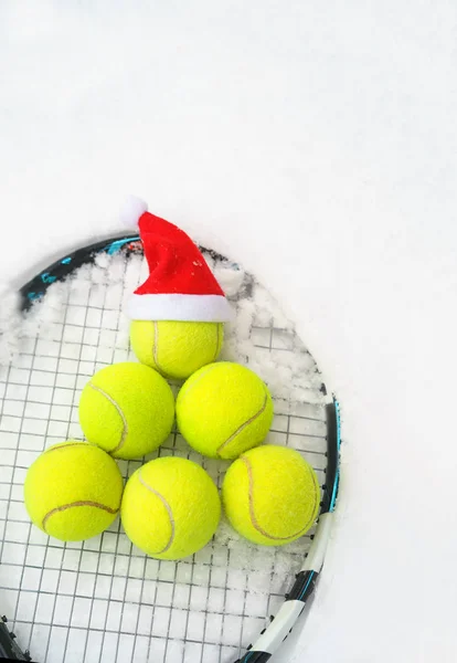 Tomtemössa på tennisboll, set med tennisbollar i form fir tree på racket på vit snö vinter bakgrund. God jul och nyår koncept med tennis spela. Närbild, sport livsstil, roligt. — Stockfoto