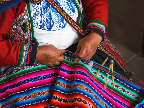 Primer plano de tejido en Perú. Cusco, Perú. Mujer vestida con colorido tradicional peruano nativo cerrando tejiendo una alfombra con patrón nacional —  Fotos de Stock