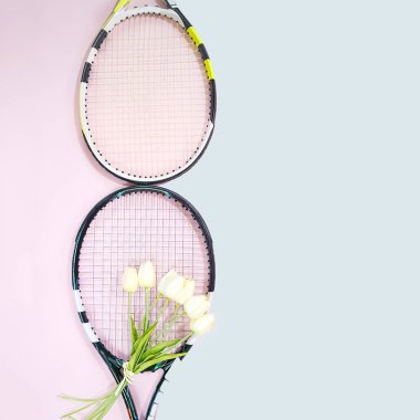 Uluslararası Kadınlar Günü 8 Mart şekli tenis raketleri buket beyaz laleler ve pastel pembe ve mavi arka plan üzerinde kopya alanı ile yapılır. Tenis oyun ile Sevgililer günü kavramı. Düz yatıyordu