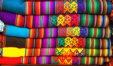 Machu Picchu, Dünyanın Yeni Yedi Wonder biri, Cusco Bölgesi Peru, Güney Amerika pazarında Perulu geleneksel renkli yerli el sanatları tekstil kumaş. Seçici odaklama.