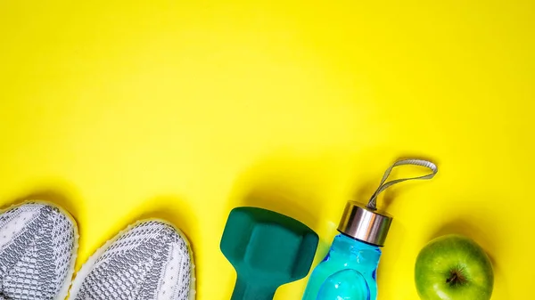 Composición plana con equipo de fitness y espacio para texto sobre fondo de color amarillo. estilos de vida saludables y activos amor concepto deportes zapatillas de deporte, botella de agua mancuerna de manzana. Copiar espacio —  Fotos de Stock