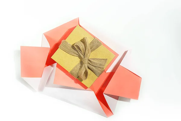 礼物的概念从白色背景上的活珊瑚颜色纸上展开。礼物为生日, 情人节, 假期。平面铺设, 复制空间. — 图库照片