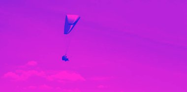 Skydiver ile gökyüzü arka plan üzerinde paraşüt. Aktif yaşam tarzı. Aşırı spor. Tatil, tatil, turizm kavramı. Mor mavi çift tonlu arka plan. Renk tonlu, Çift tonlu Macenta ultraviyole