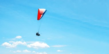 Güneşli mavi gökyüzü arka plan üzerinde renkli bir paraşüt ile skydiver. Aktif yaşam tarzı. Aşırı spor. Yaz tatili, tatil, turizm kavramı. Yatay