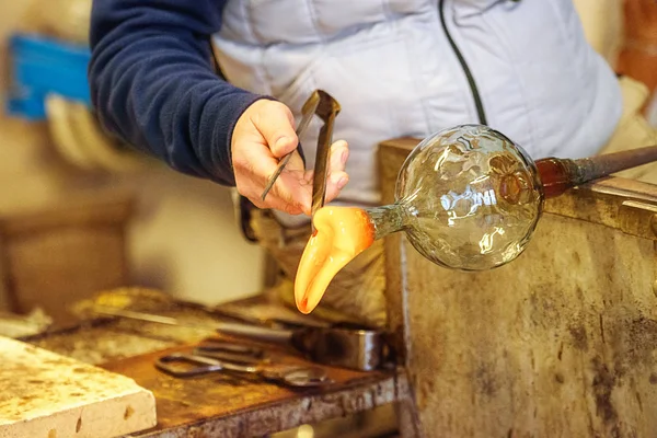 The processing of Murano glass, Venice, Veneto, Italy. A master glassmaker working with the most famous in the world murano glass with fire, crafts in manufacture.