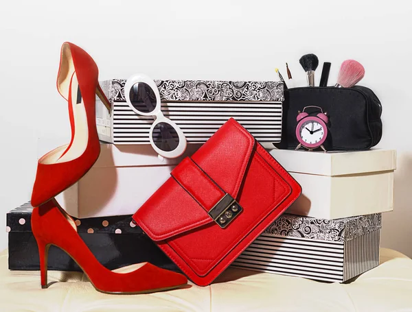 Penampilan teratas komposisi pakaian pesta aksesoris perempuan aksesoris tas tangan sepatu merah kacamata hitam jam alarm kosmetik untuk pesta di kotak karton pada latar belakang putih. Elegance fashion pakaian musim panas . — Stok Foto