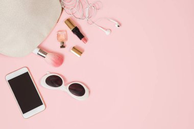 Düz kadın aksesuarları pastel pembe kozmetik güneş gözlüğü cep telefonu kulaklık makyaj yatıyordu. Sevgililer günü 8 Mart doğum günü partisi kıyafet düzeni. Kavram online alışveriş. Üstten Görünüm.