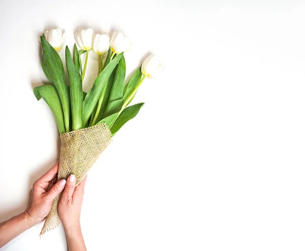 Kytice z bílých tulipánů v ženské ruce na bílém pozadí. Pojem dárek pro Valentýna, narozeniny, 8 březen. Kopírovat prostor. — Stock fotografie