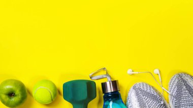 Sarı arka plan üzerinde fitness ekipmanları ile düz yatıyordu kompozisyon.