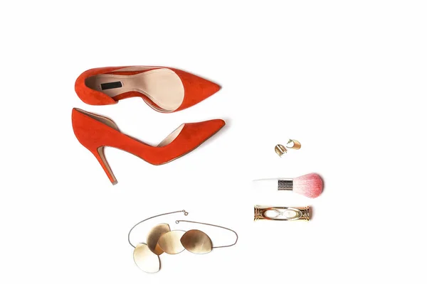 Плаский наряд: червоне взуття, аксесуари, прикраси, макіяж на білому тлі . — стокове фото