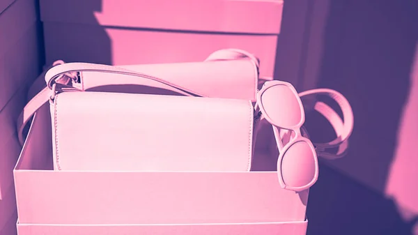 Concepto de moda accesorios femeninos bolsas gafas de sol en cajas vacías y fondo rosa . — Foto de Stock