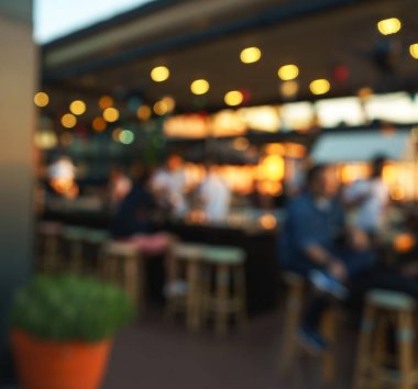 Bokeh ve parlak ampuller ile restoran, bar veya gece kulübünde oturan müşteri erkeklerin bulanık arka plan.