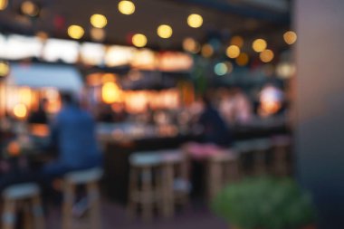 Bokeh ve parlak ampuller ile restoran, bar veya gece kulübünde oturan müşteri erkeklerin bulanık arka plan.
