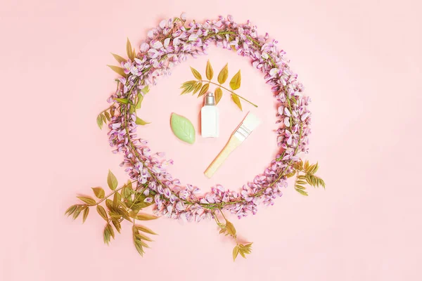 Kroužek s kosmetickými zákérkami a krásnou wisterii květy s květy poupata na růžovém pozadí. — Stock fotografie