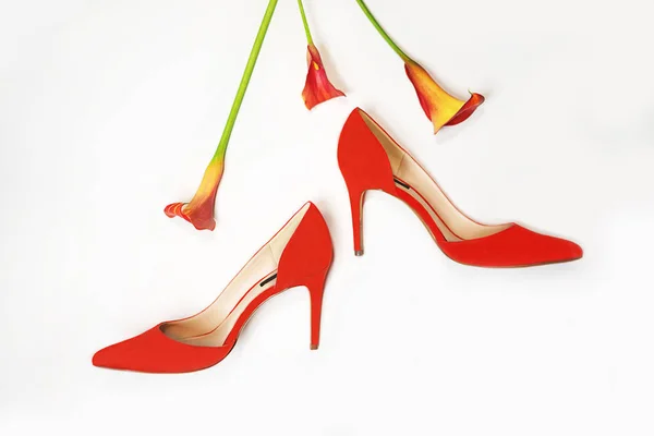 Accessoires élégants féminins ensemble de vêtements de luxe de mode : chaussures rouges et fleurs en couleur corail et fond blanc . — Photo