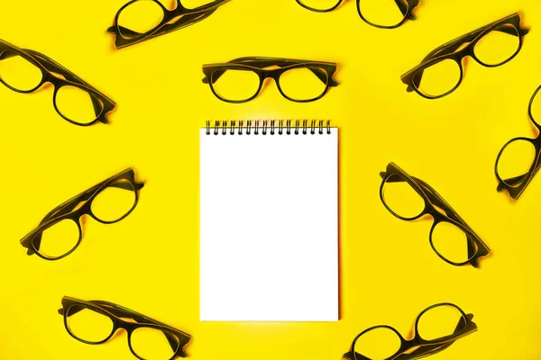 Bloc de notas con gafas de moda sobre fondo amarillo claro . — Foto de Stock