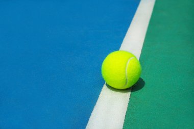 Sert tenis kortunda beyaz hat üzerinde tenis topu ile yaz spor konsepti.
