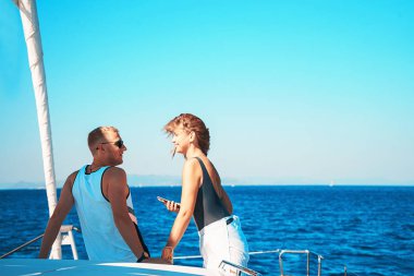 Yaz tatilinde yelkenli teknede aşık çift.