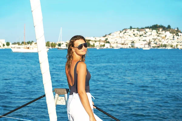 Giovane donna felice in occhiali da sole si sente divertente sulla barca a vela di lusso catamarano yacht in mare turchese in vacanze estive, Grecia. — Foto Stock