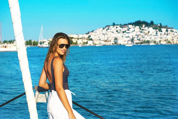 Giovane donna felice in occhiali da sole si sente divertente sulla barca a vela di lusso catamarano yacht in mare turchese in vacanze estive, Grecia. — Foto Stock