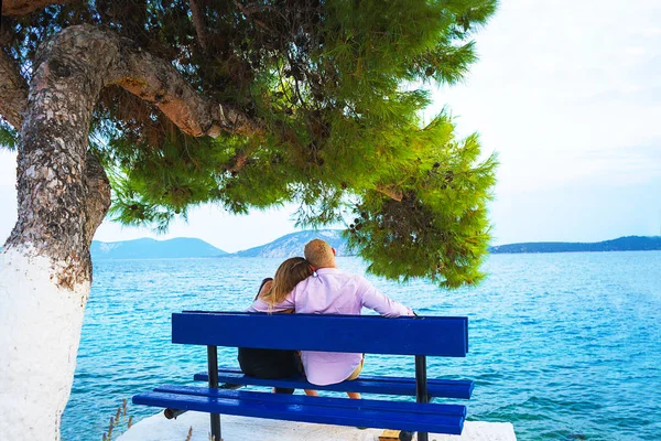 Fiatal boldog szerelmesek szórakozik Nézd meg a tengeren a kék padon nyaraláskor nyaralás. — Stock Fotó