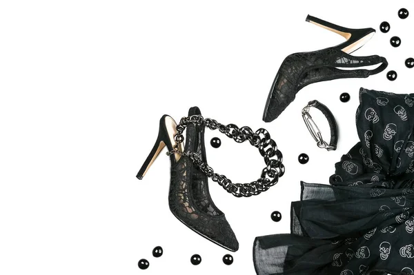 Halloween party accessori collezione abbigliamento femminile nero su sfondo bianco, scarpe, stoffa con teschi, gioielli . — Foto Stock