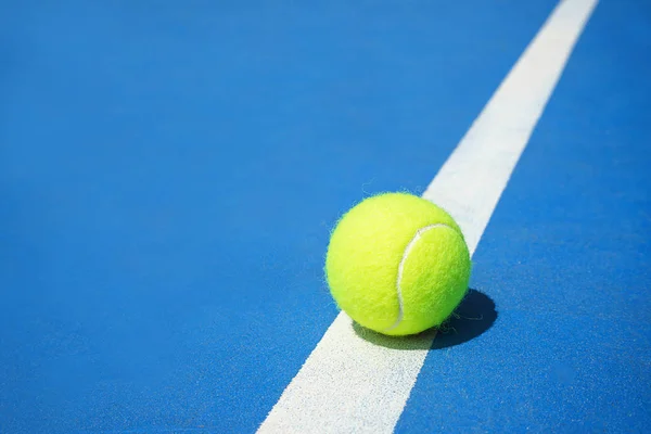 Sert tenis kortu mavi renk beyaz çizgi üzerinde tenis topu ile yaz spor konsepti.