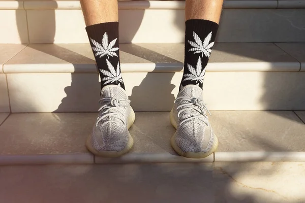 Adultos jóvenes usan calcetines altos con imágenes de hojas de cannabis . Fotos de stock