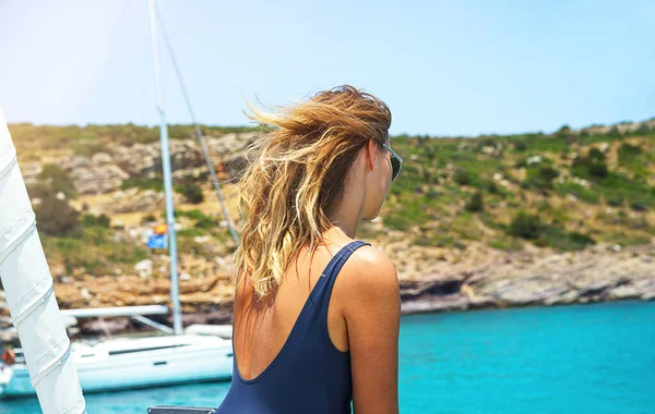 Mladá šťastná žena v slunečních brýlích cítí zábavu na luxusní plachetnici jachty katamarán v tyrkysovém moři v letních prázdninách, Řecko. — Stock fotografie
