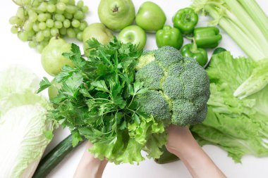 brokoli ellerinde arka plan Yeşil taze meyve - elma, armut, kivi ve sebze - marul, salatalık, brokoli, avokado